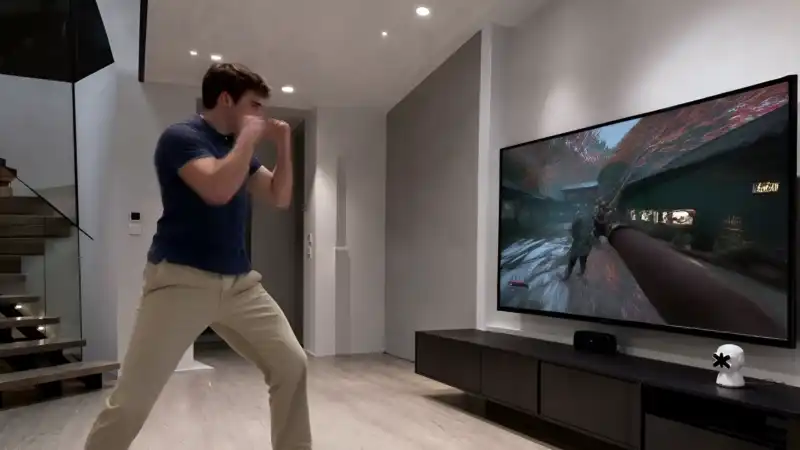 Player boxing in his living room — his punches mapped in real time to the fighting game on the TV, with nothing worn on his body